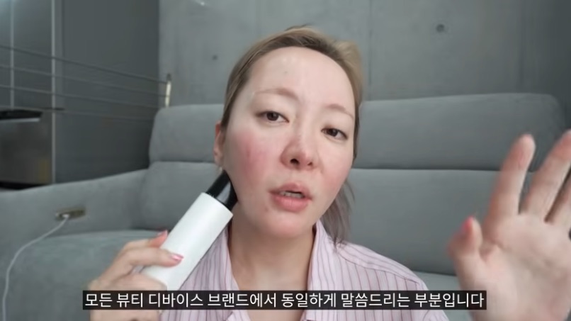 The YouTuber holding the LG Pra.L device against her jaw while giving her closing advice (video screenshot)